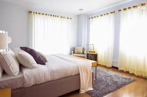 Camera da letto luminosa con letto matrimoniale e cuscini