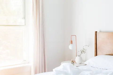 Letto bianco in una stanza minimale piena di luce