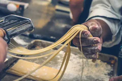Mani che lavorano la pasta fresca