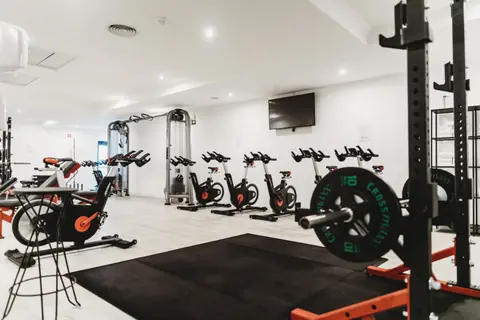Sala attrezzi luminosa con bilancieri e bike